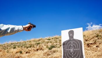 Shooting handgun at human silhouette target.