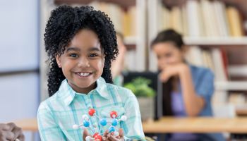 African American elementary schoolgirl learns about molecular structure