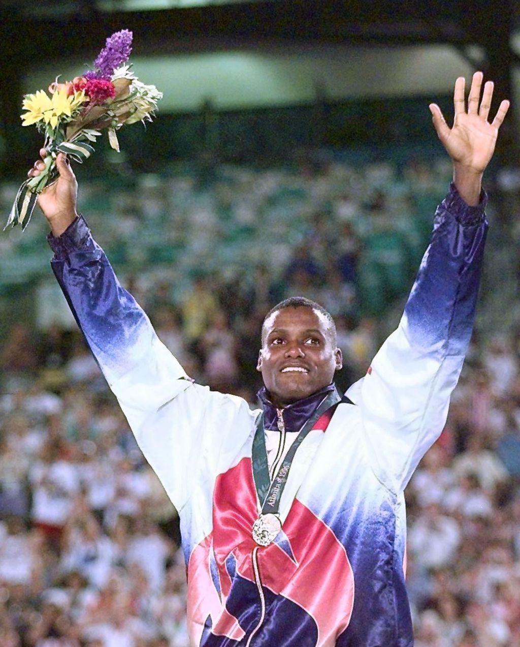 Carl Lewis of the US waves from the podium after r