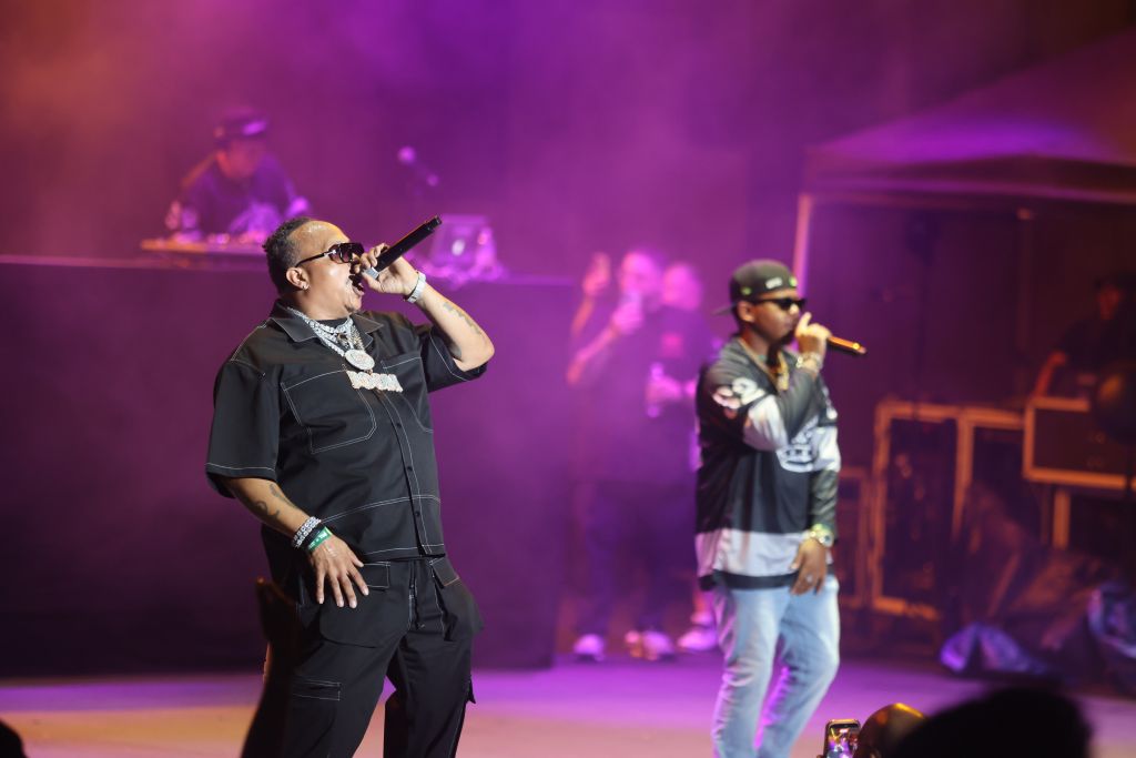 Two men performing on stage in a colorful, smoke-filled environment.